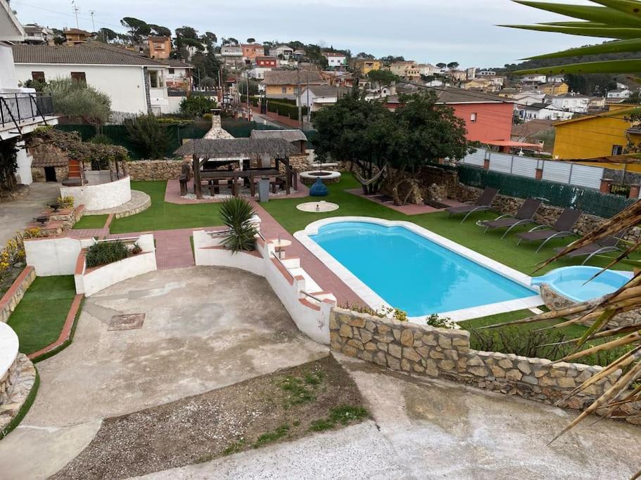 un patio trasero con piscina, mesa y sillas en Villa con piscina privada Costa brava, en Maçanet de la Selva