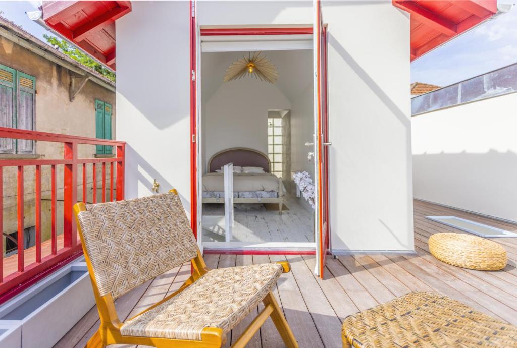 Cette chambre dispose d'un balcon avec une chaise et d'un lit. dans l'établissement VillaGigi Maison de Plage en plein cœur d'Arcachon, à Arcachon