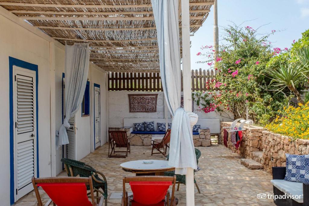 a patio with a table and chairs and a table at B&B Cala Pisana (Paola e Melo) in Lampedusa