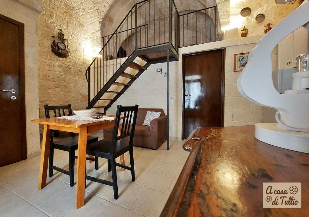 comedor con mesa y escalera de caracol en A casa di Tullio en Fasano