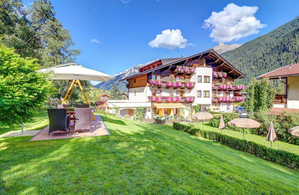 un grand bâtiment avec une pelouse devant lui dans l'établissement Hotel Christoph, à Neustift im Stubaital