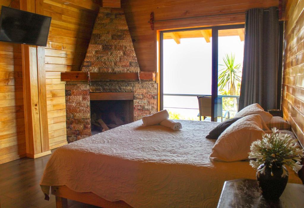 a bedroom with a bed and a fireplace at San José del Pacífico Camino al Cielo in El Pacífico