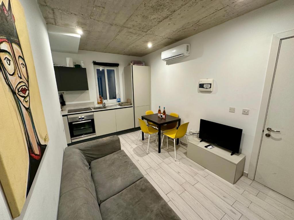 a living room with a couch and a table at Heart of the Paceville Modern Apartment! in St. Julianʼs