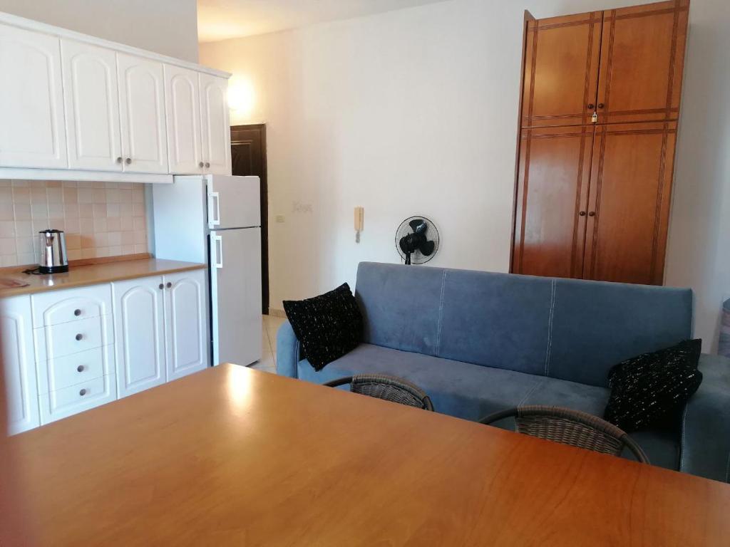 Il comprend un salon avec un canapé bleu et une cuisine. dans l'établissement Уютная квартира на берегу Адриатического моря, à Durrës