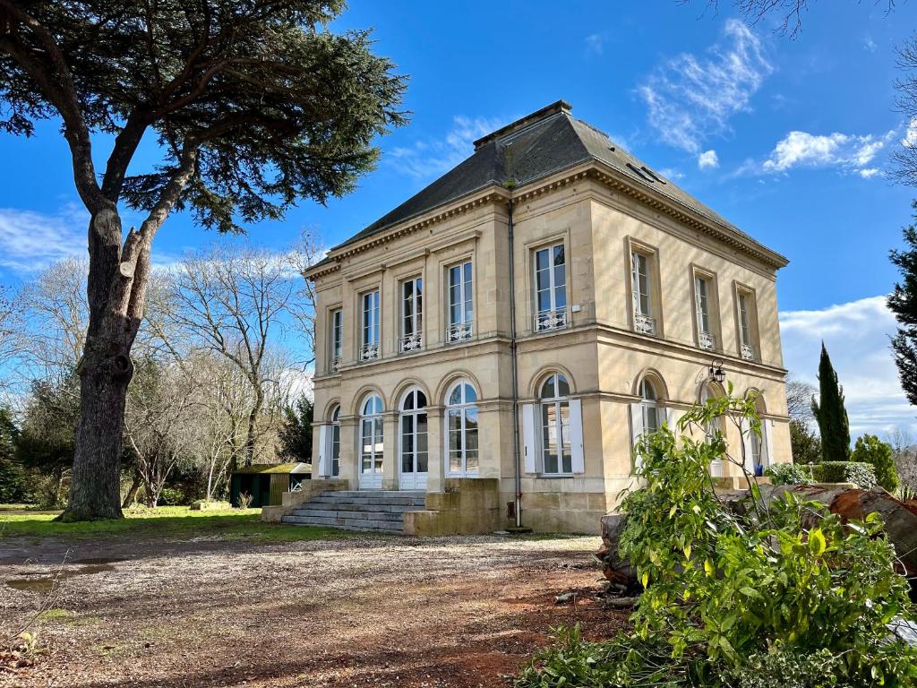 Una casa vieja con un árbol delante. en Superbe Maison de maître 10 chambres 300 m2 Caen en Bretteville-sur-Odon