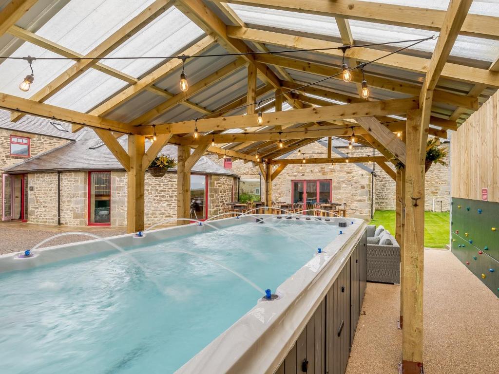 a large swimming pool with a wooden pergola at 8 Bed in Allendale 90713 in Catton