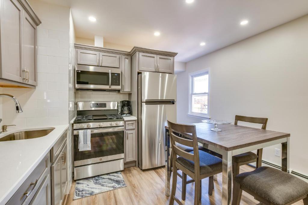 uma cozinha com uma mesa, um frigorífico e um lavatório em Convenient Newark Apartment about 15 Mi to Manhattan! em Newark