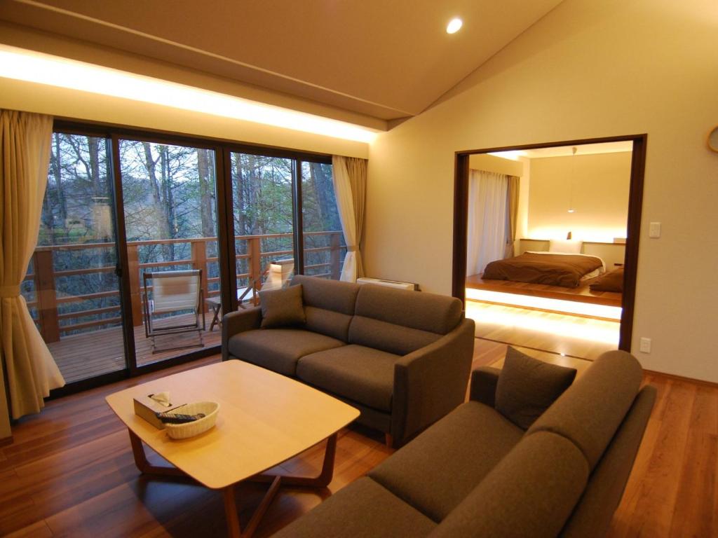 Rental Villa Karuizawa Honors Hill - Vacation STAY 04109v في Oiwake: غرفة معيشة مع أريكة وطاولة
