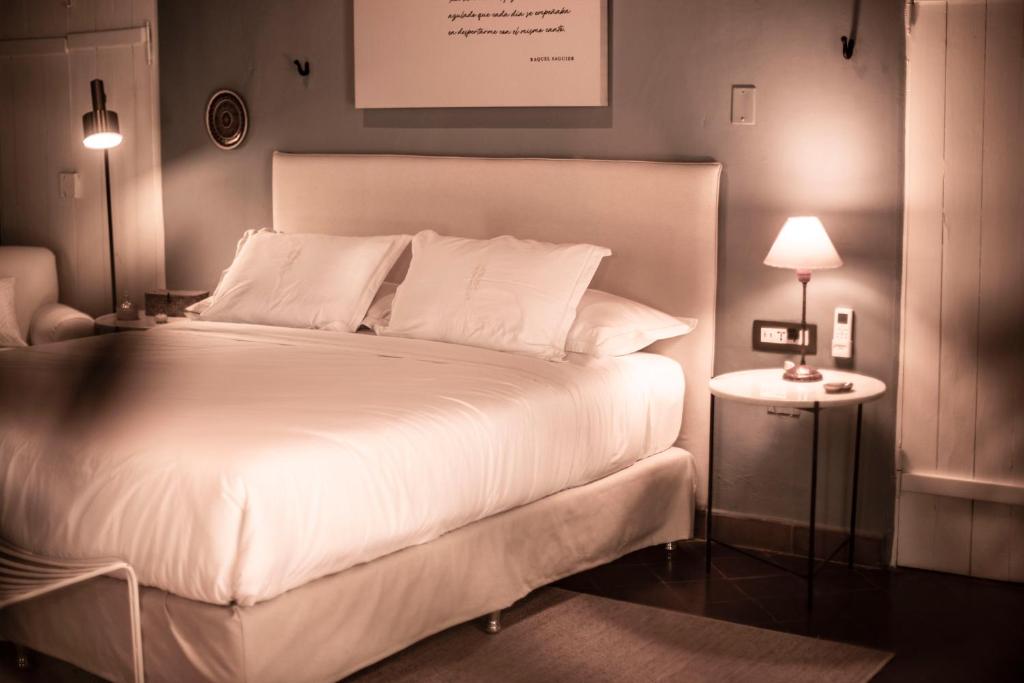 una camera da letto con un grande letto con lenzuola e cuscini bianchi di Casa Del Val- Villa Maria a San Bernardino