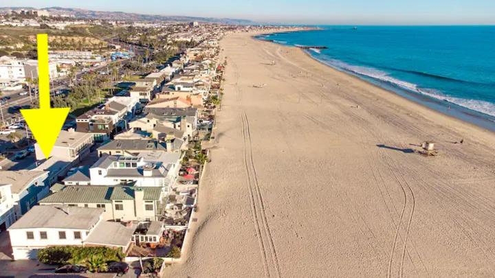 an aerial view of a beach with a yellow arrow at 2 Bedroom steps to the beach in West Newport in Newport Beach