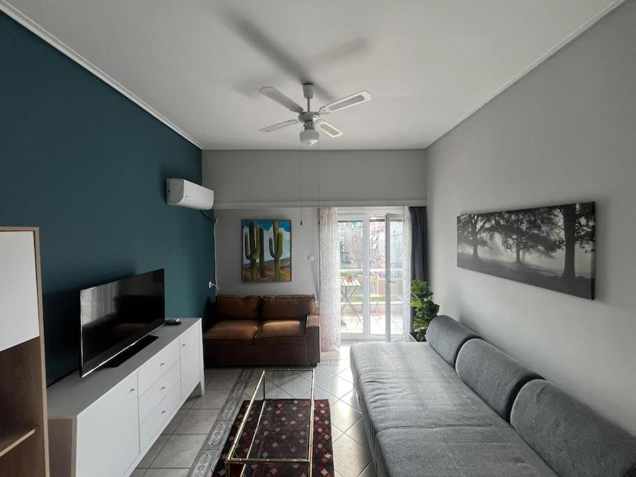 a living room with a couch and a television at Maria's Sunlit Apartment in Piraeus