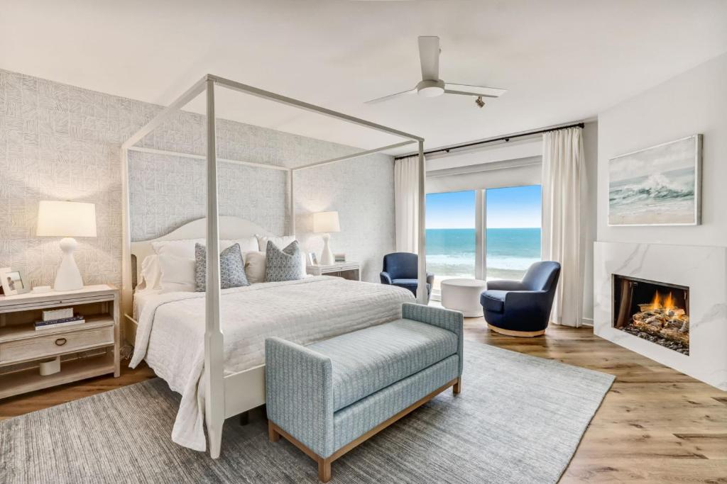 阿米莉亞島的住宿－Elegant Oceanfront Penthouse with Panoramic view, Omni Resort, Sea Dunes，一间卧室设有一张天蓬床和一个壁炉