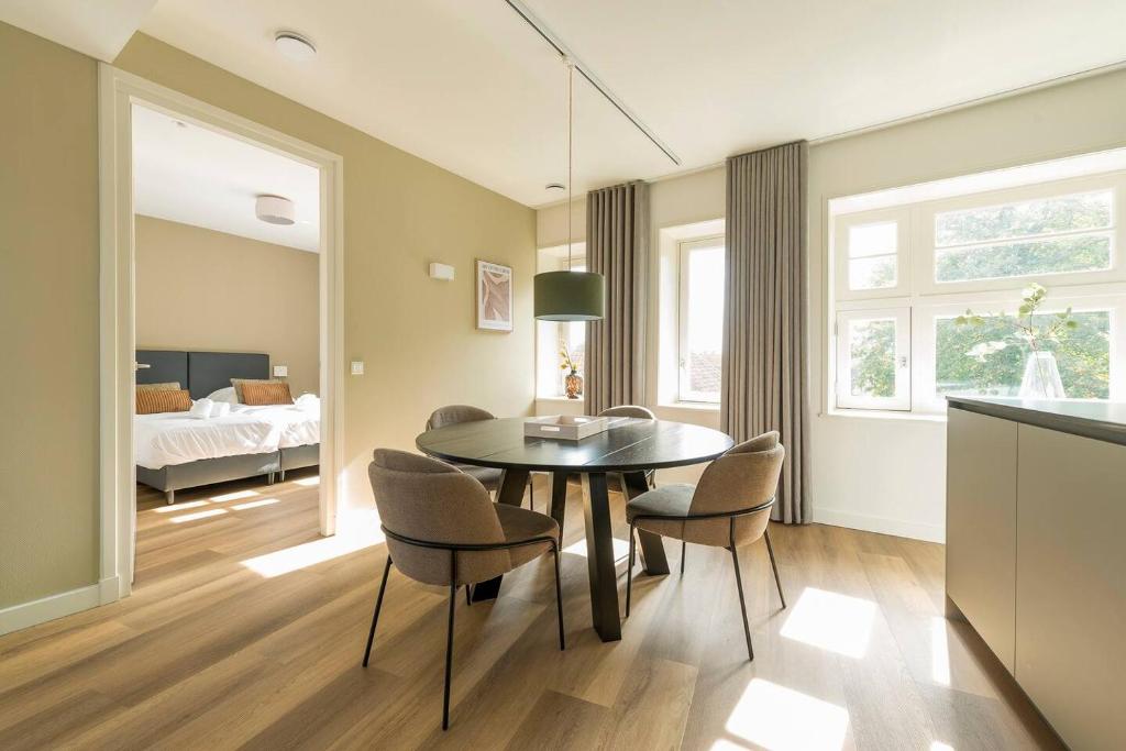 a dining room with a table and chairs and a bedroom at Oirschot 6c New Renovated Apartement in Oirschot