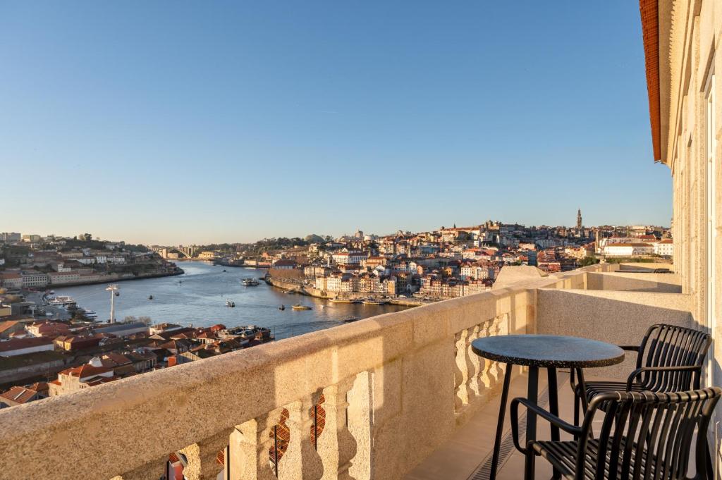 a balcony with a table and chairs and a view of a river at Host Wise - Fervença Boutique Palace in Vila Nova de Gaia