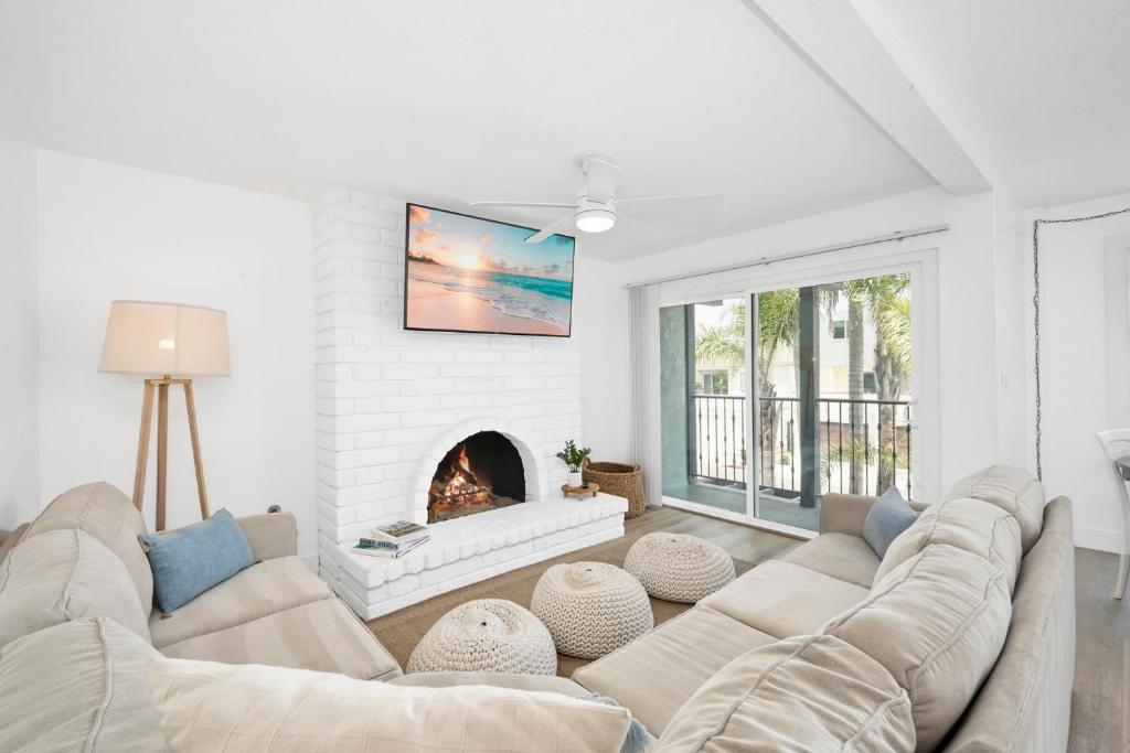 sala de estar con sofá y chimenea en NEW - 3 Bedroom near the Balboa Pier and Fun Zone with AC, en Newport Beach