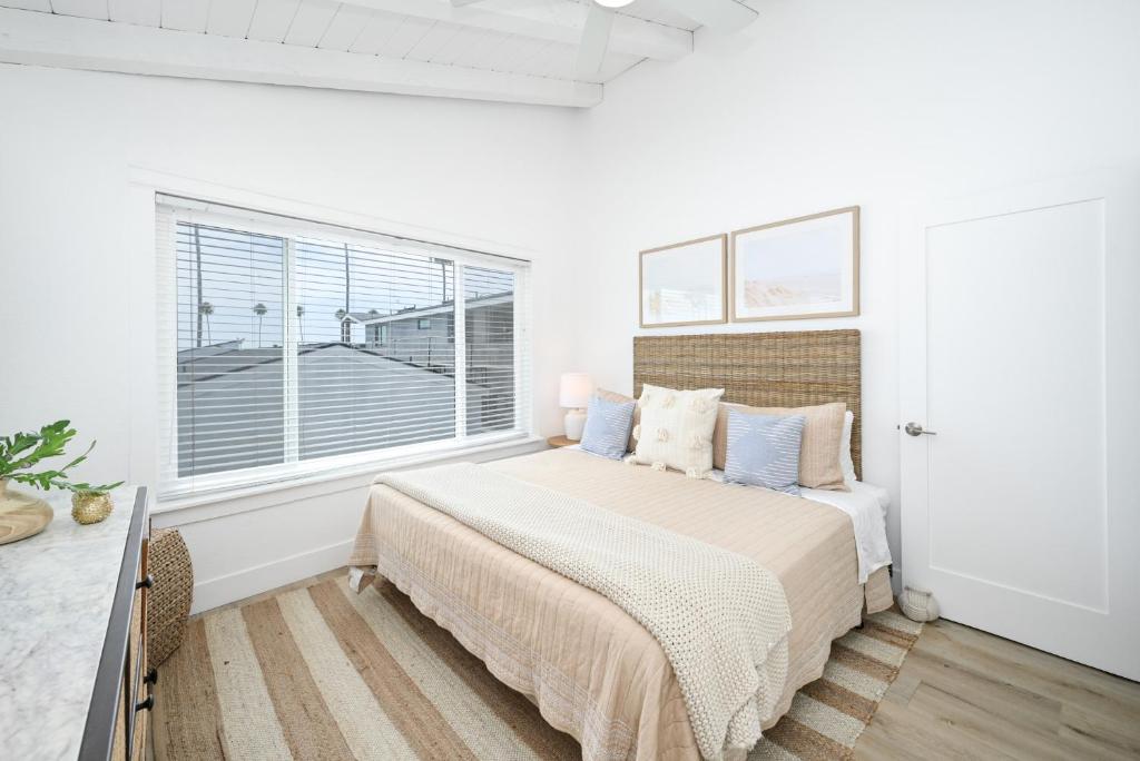 um quarto branco com uma cama e uma janela em 6 Bedroom Duplex near the Balboa Pier and Fun Zone with AC em Newport Beach