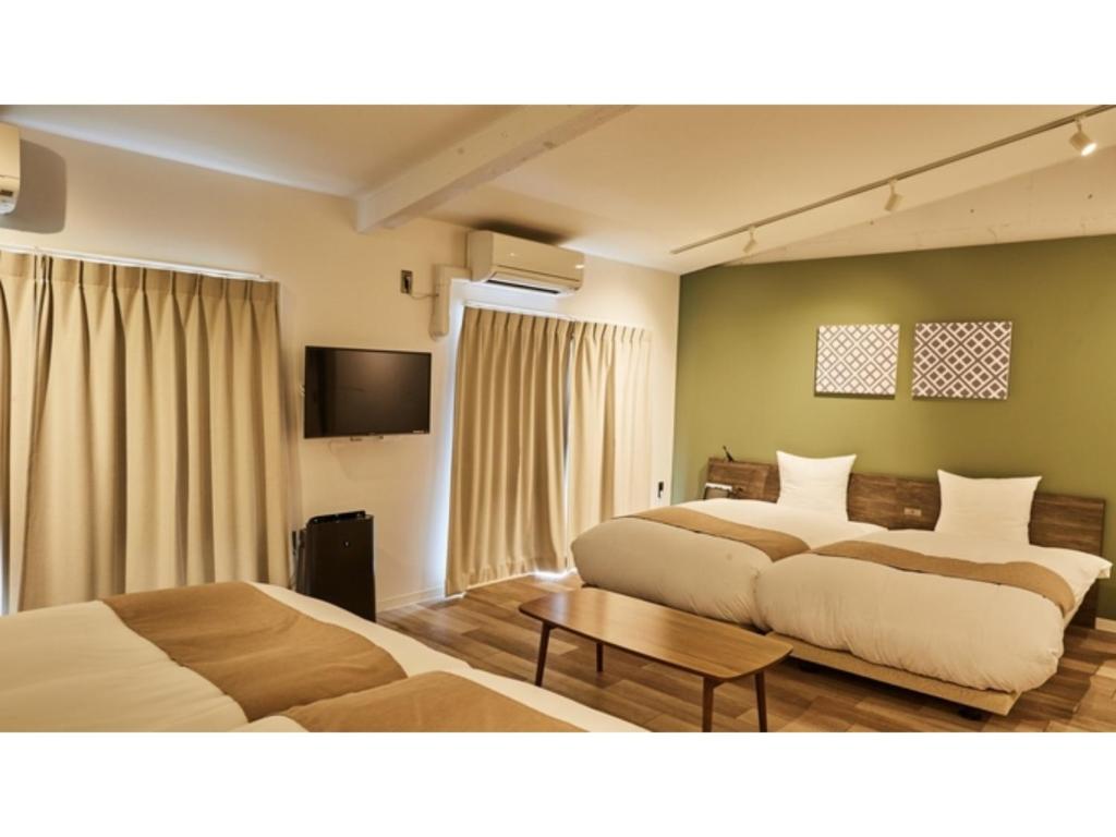 京都市にあるRiver Side Arashiyama - Vacation STAY 86216vのベッド2台とテレビが備わるホテルルームです。