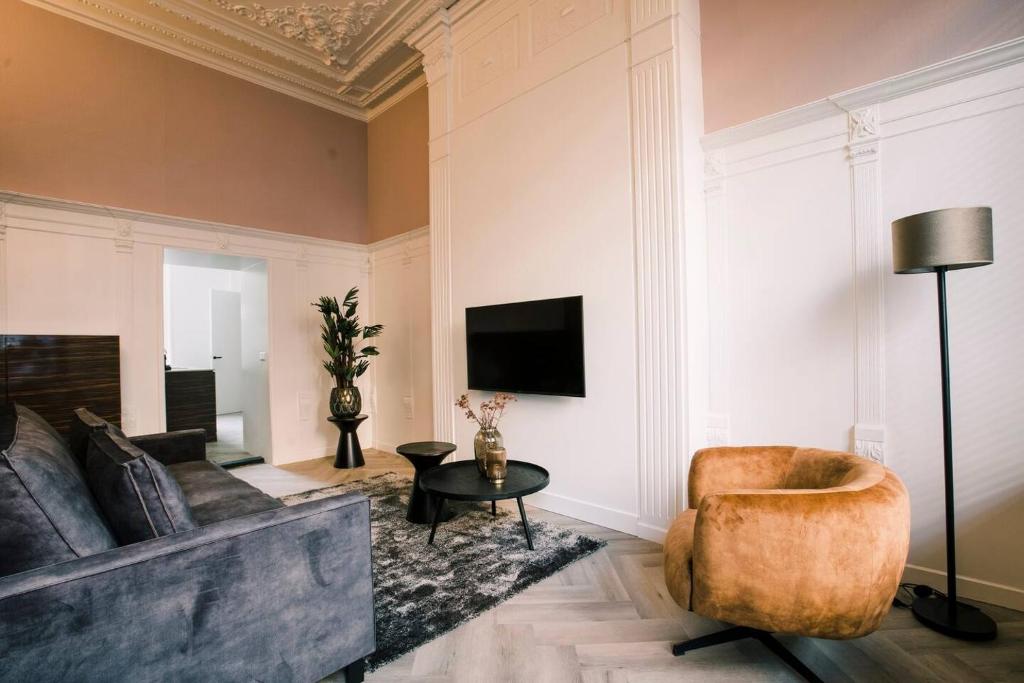 Luxious Apartment Wilhelmina في تيلبورغ: غرفة معيشة مع أريكة وطاولة