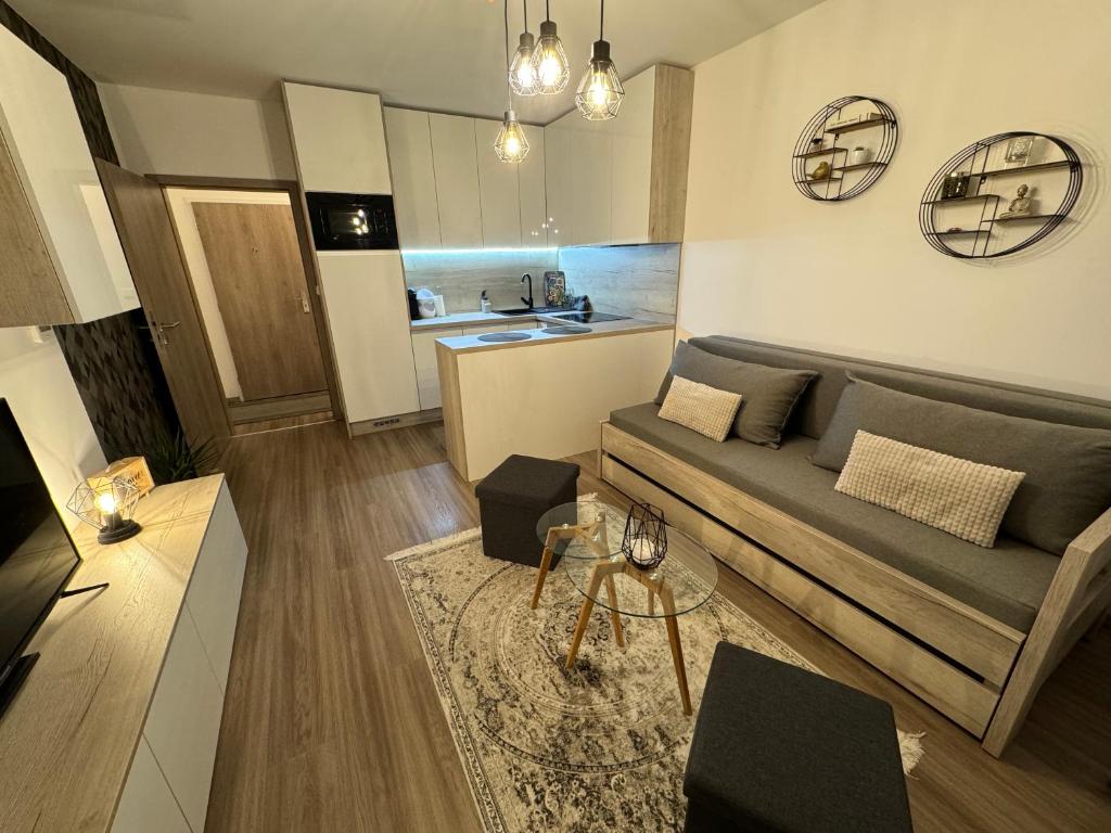 uma sala de estar com um sofá e uma mesa em Moderný apartmán s výhľadom na Vysoké Tatry em Poprad