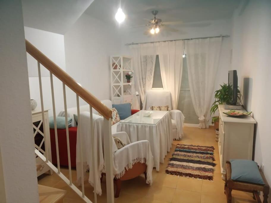 a living room with a table and a staircase at Preciosa casa cerca del mar in La Redondela