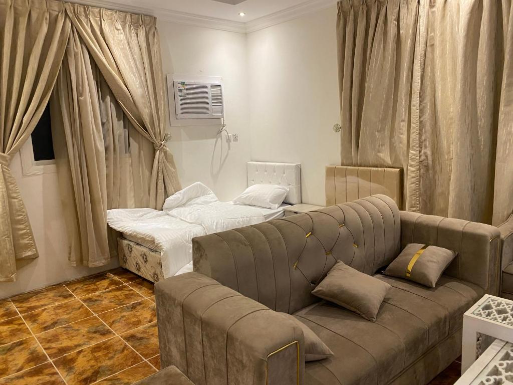 العلم نور في Sīdī Ḩamzah: غرفة معيشة مع أريكة وسرير
