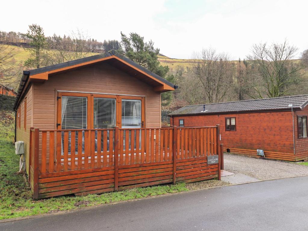 a house with a wooden fence in front of it at Lakeland View Lodge in Windermere