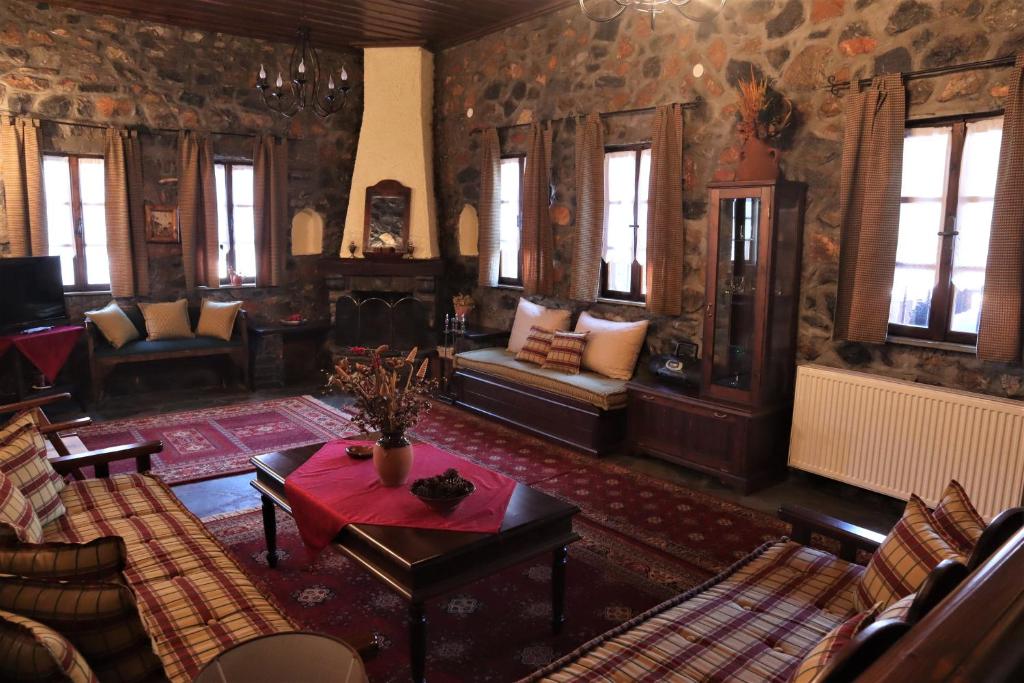 a living room with couches and a table at Gaea Mont Chalet in Palaios Agios Athanasios