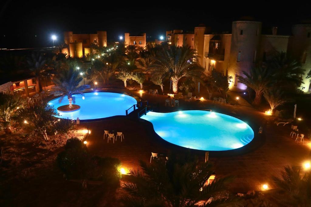 2 piscinas por la noche con luces en Palais Du Desert Hotel & Spa en Erfoud