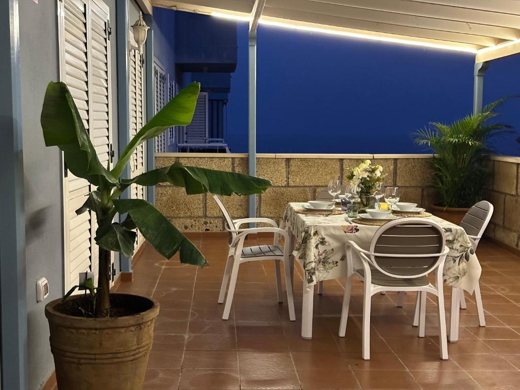 a table and chairs on a balcony with a plant at Luminoso apartamento con amplia terraza y vistas in Candelaria