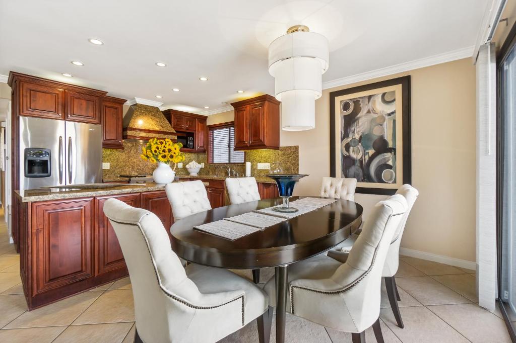 cocina con mesa de comedor y sillas blancas en 3 Bedroom Home in Balboa - Walk to Pier & Restaurants, en Newport Beach