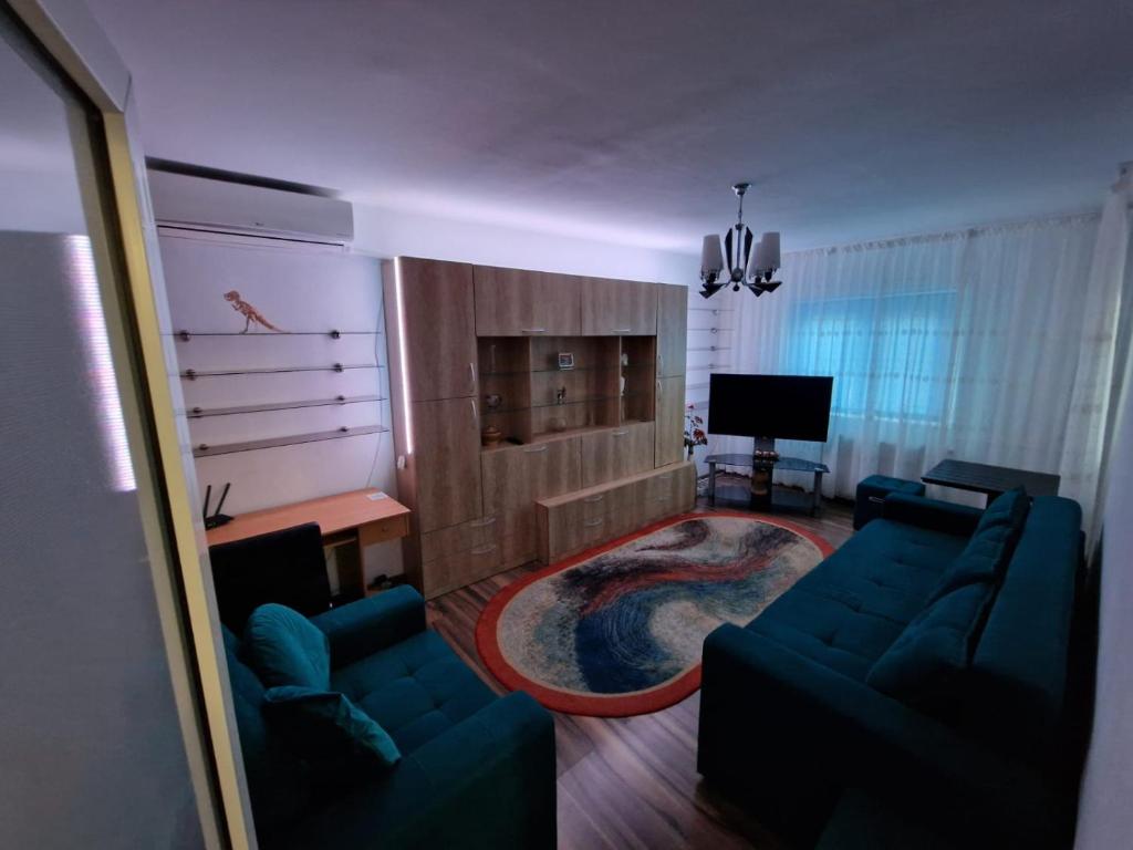 een woonkamer met twee blauwe banken en een televisie bij DurAsset Home in Ploieşti