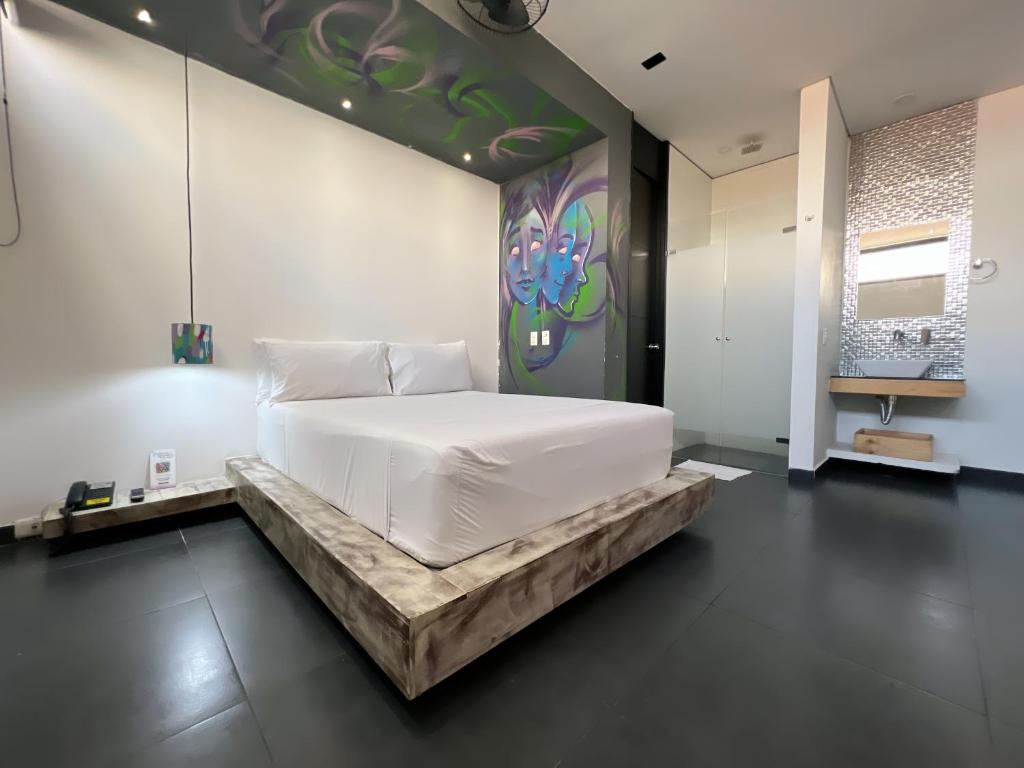 una camera con un letto bianco e un dipinto sul muro di Hotel Medellin Art a Medellín