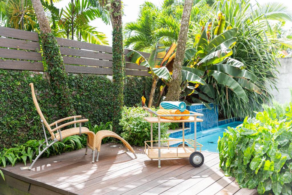 a wooden deck with chairs and a table next to a pool at Garden Oasis 1 Villa With Private Pool in Four Roads