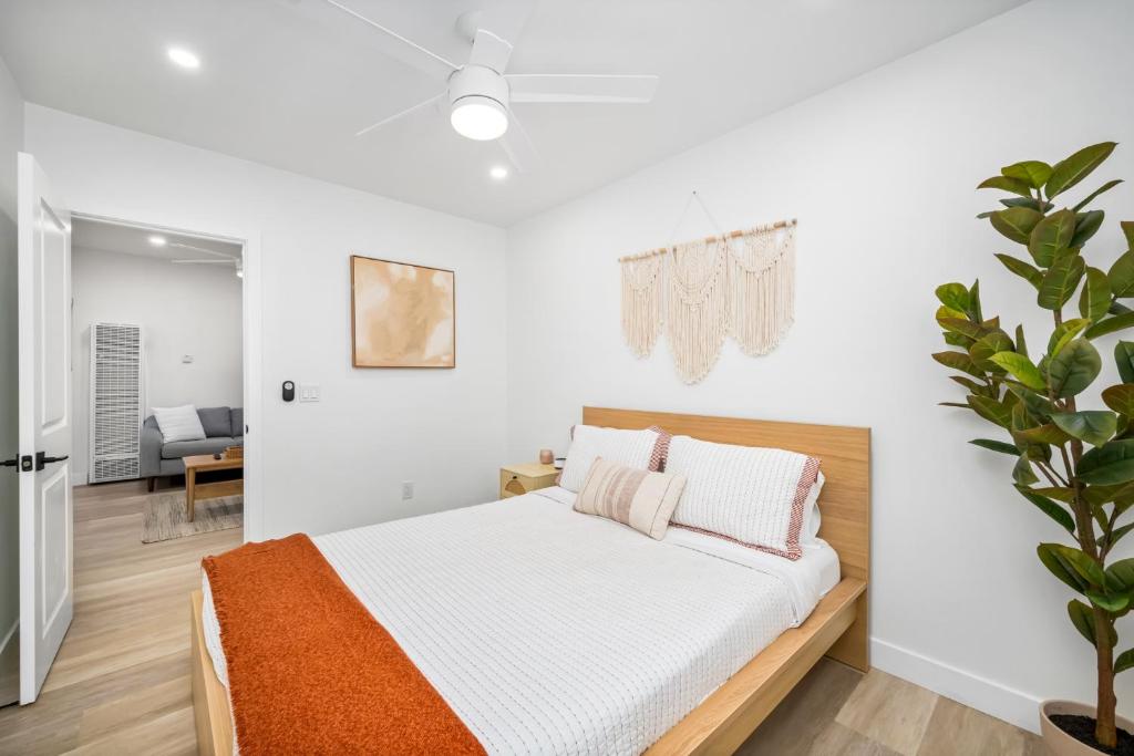 a white bedroom with a bed and a plant at 130 Anderson St B in Sunset Beach
