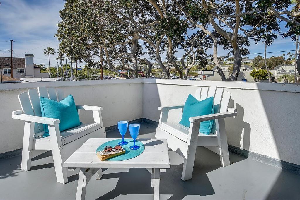 dos sillas y una mesa con un plato de comida y dos vasos en 2 Bedroom Upstairs Apt 1 block from the beach! en Newport Beach