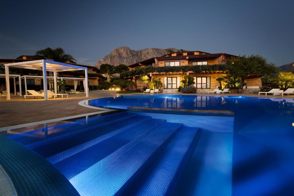 a large swimming pool in front of a house at Magaggiari Hotel Resort in Cinisi