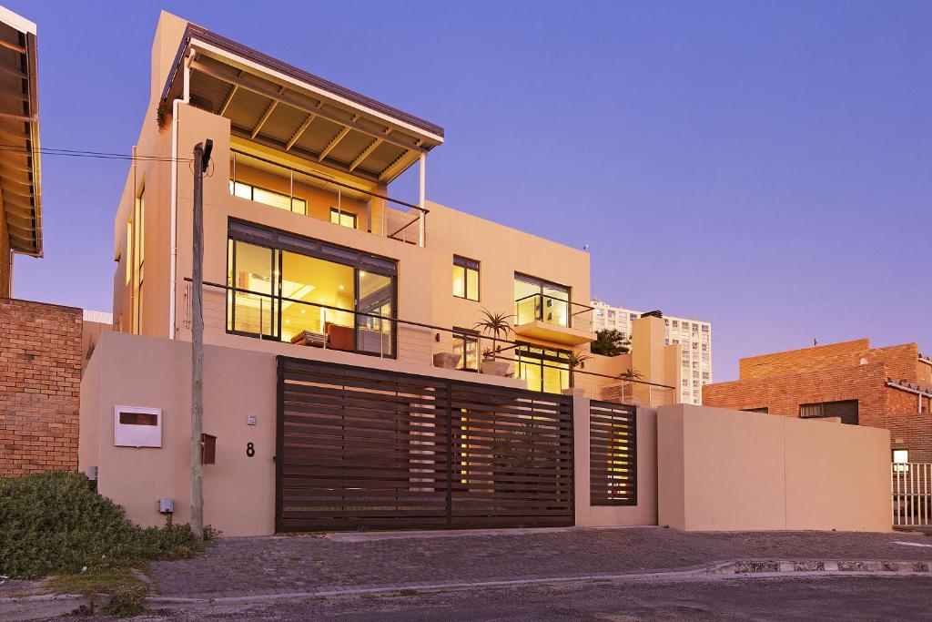 a house with a garage door in front of it at Biccard Blouberg Villa by HostAgents in Cape Town
