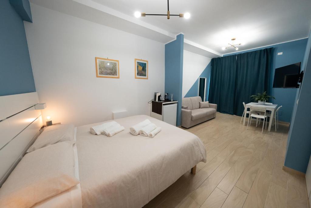 ein Schlafzimmer mit einem weißen Bett und ein Wohnzimmer in der Unterkunft PALAZZO ENNIO in Bari