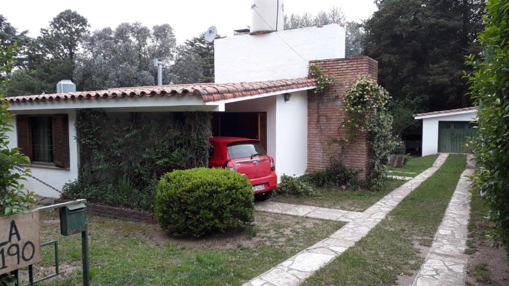 ein rotes Auto, das in der Garage eines Hauses geparkt ist in der Unterkunft la soñada in Villa Icho Cruz