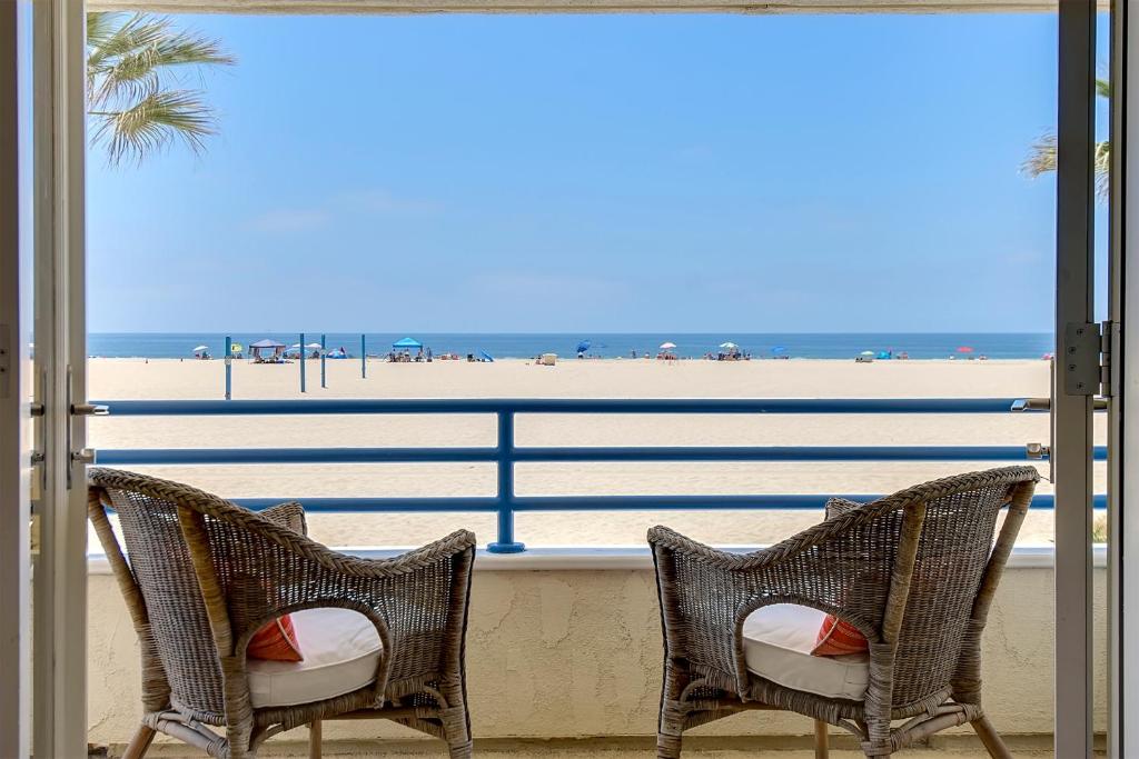 2 sillas en un balcón con vistas a la playa en Multi Level Oceanfront Home With Oceanviews and Private Patio on the Sand, en Newport Beach