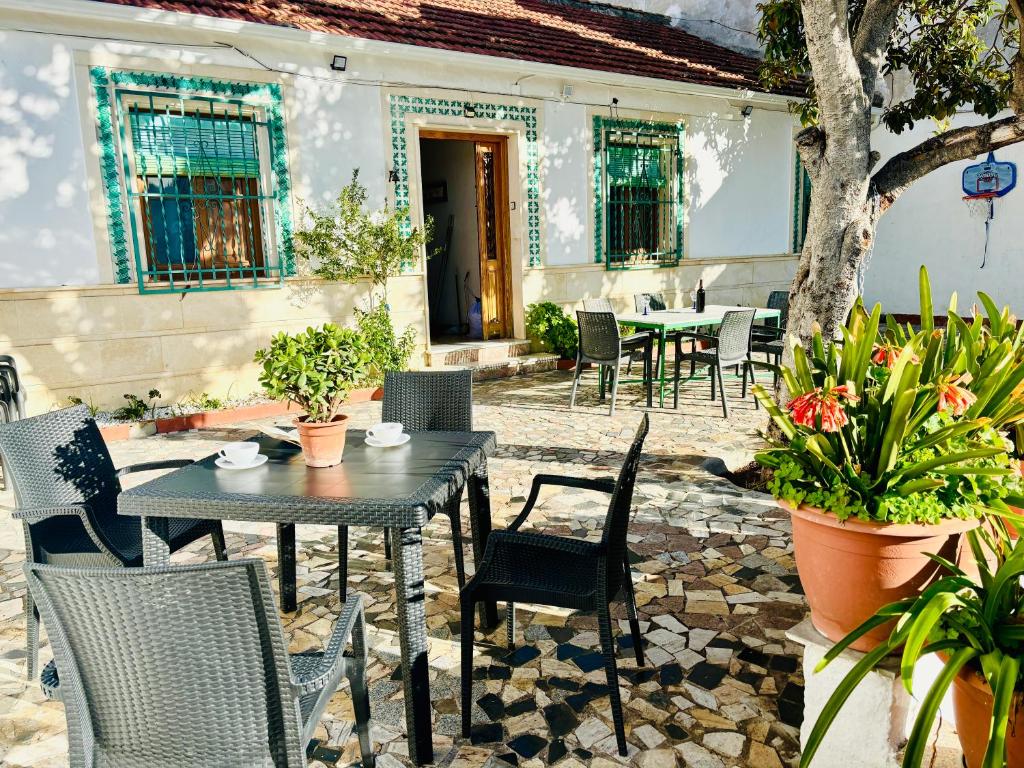 un patio con mesa, sillas y plantas en Super casa al lado de Granada, en Alfacar
