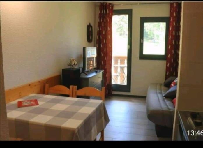 un salon avec un lit et un canapé dans l'établissement Appartement pied des pistes, à Modane