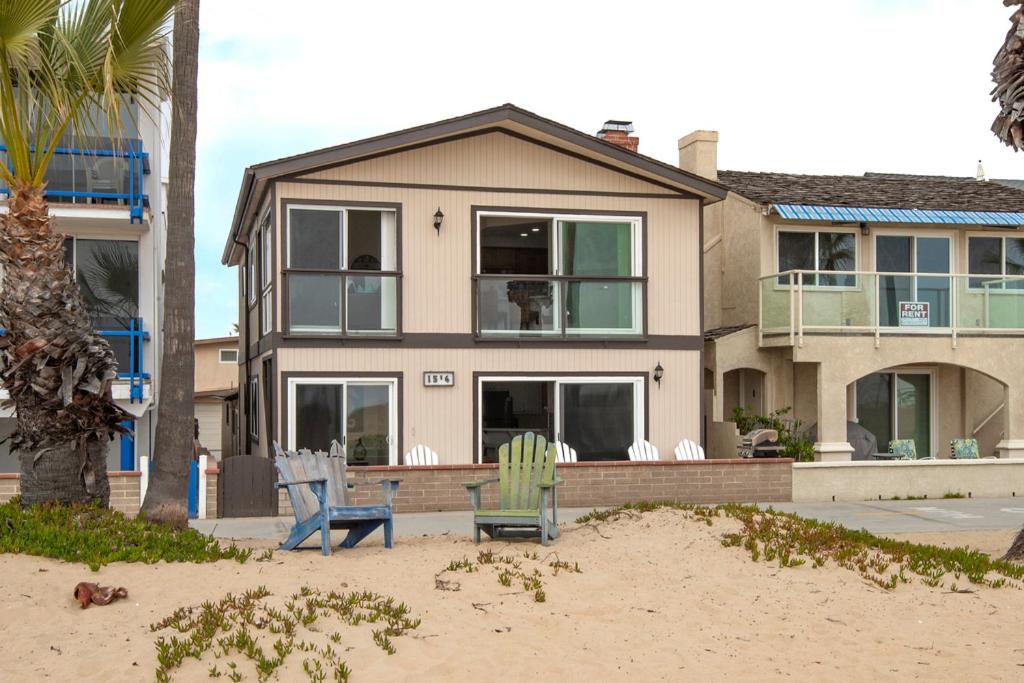 a house on the beach with two chairs at Updated Home on the Boardwalk with Private Rear Unit in Newport Beach