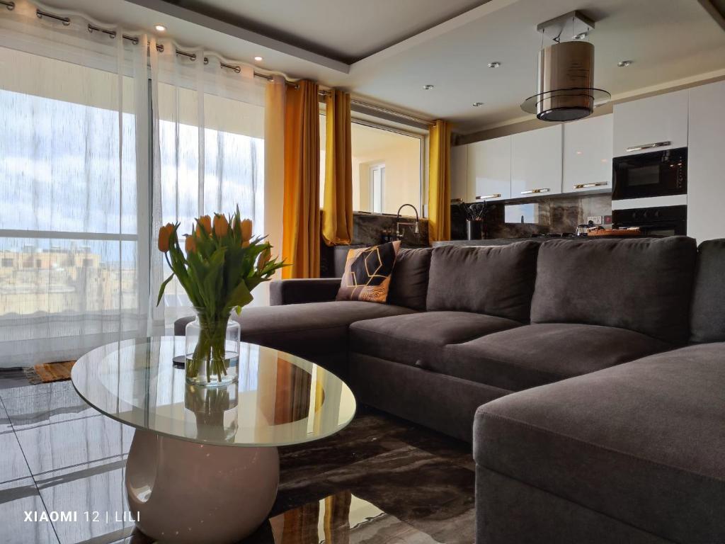 - un salon avec un canapé et une table en verre dans l'établissement Luxury Sanap Heights apartment with communal pool, à Sannat