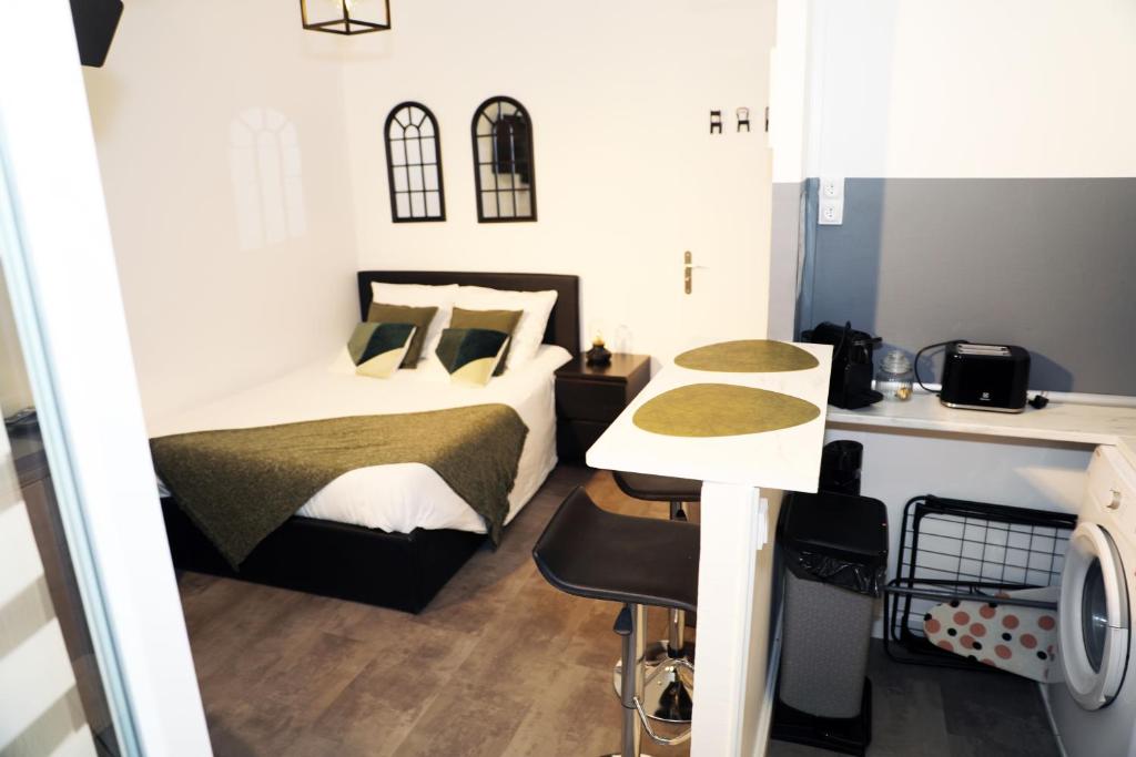 een kleine slaapkamer met een bed en een bureau bij Eiffel Tour Cosy Oliver in Parijs