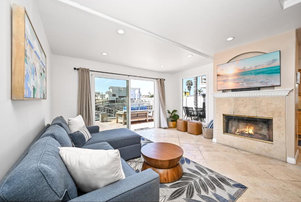 a living room with a blue couch and a fireplace at Sunset Island Waterfront Home with Kayaks across the Street from the Beach in Sunset Beach