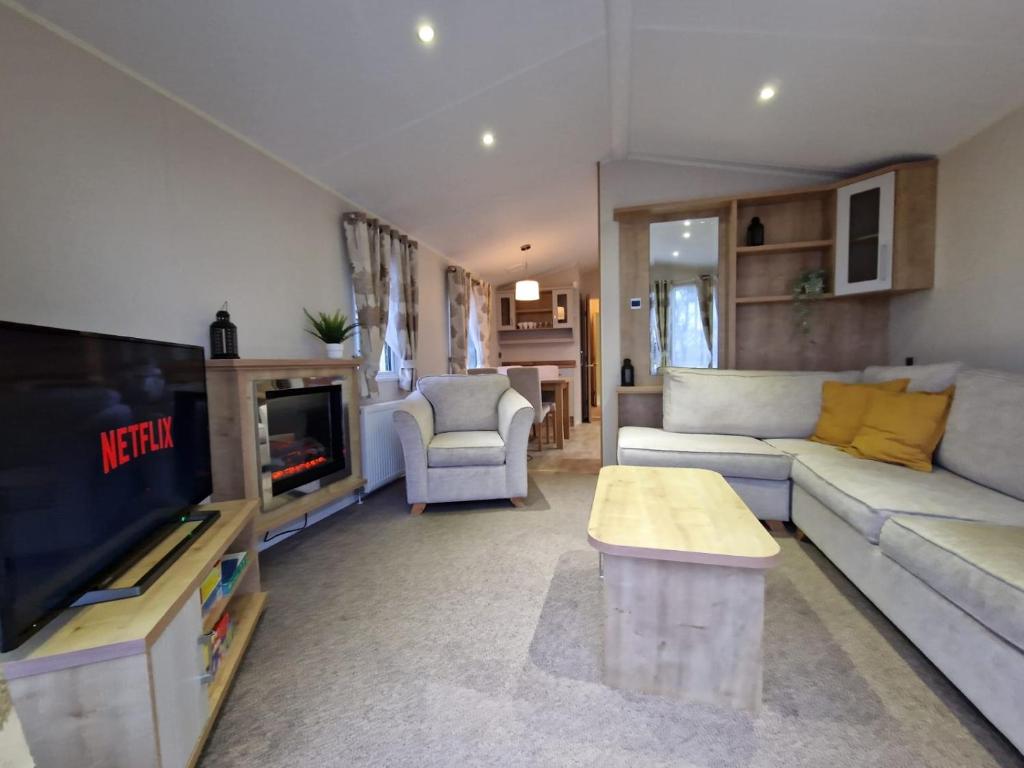 Beautiful Caravan near Edinburgh nr 9 في Port Seton: غرفة معيشة مع أريكة وتلفزيون