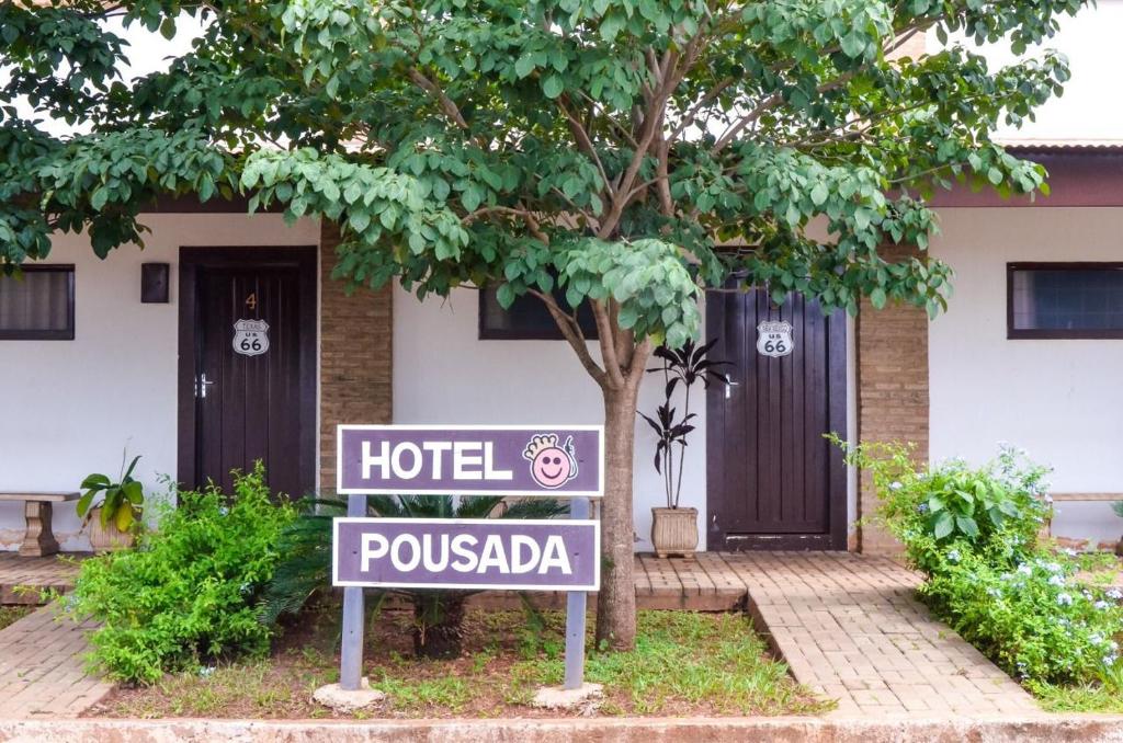 a hotel pousada sign in front of a building at Hotel Pousada Rei do Suco in Olímpia