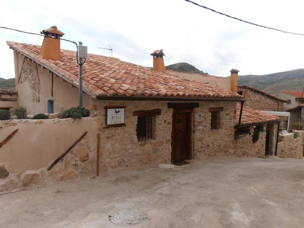 an old stone building with a red roof at Mirador del Maestrazgo in Ejulve