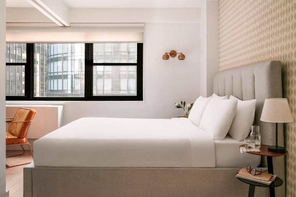 a bedroom with a large white bed and windows at Sonder at The Nash in New York